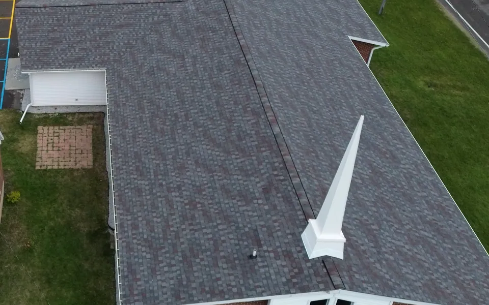 Aerial view of a broad shingle roof with intersecting roof planes
