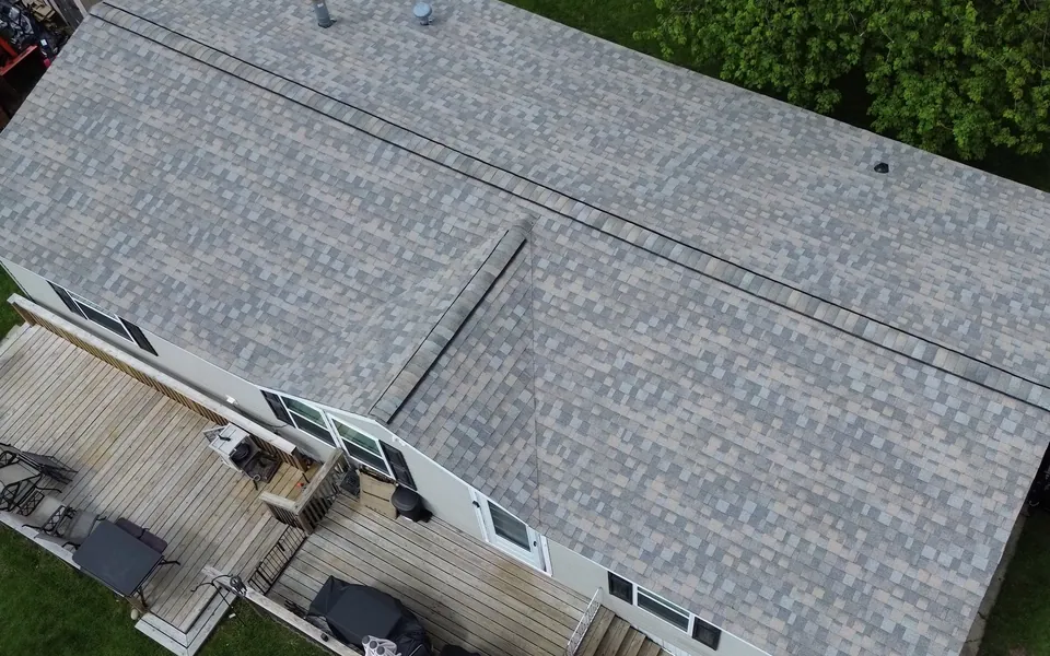 Aerial view of a light gray shingle roof with vents and a gabled roof plane