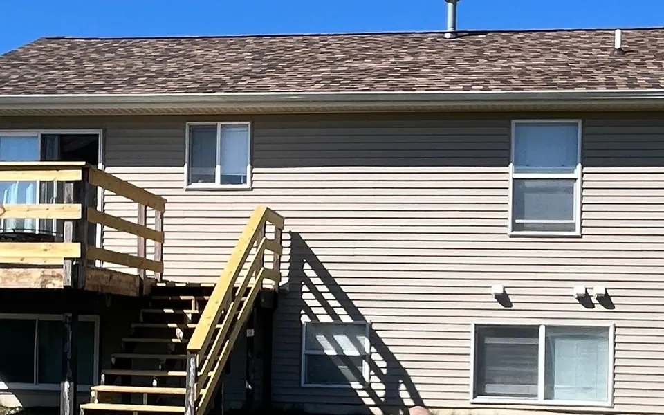Shingle roof edge and upper rear exterior of a home